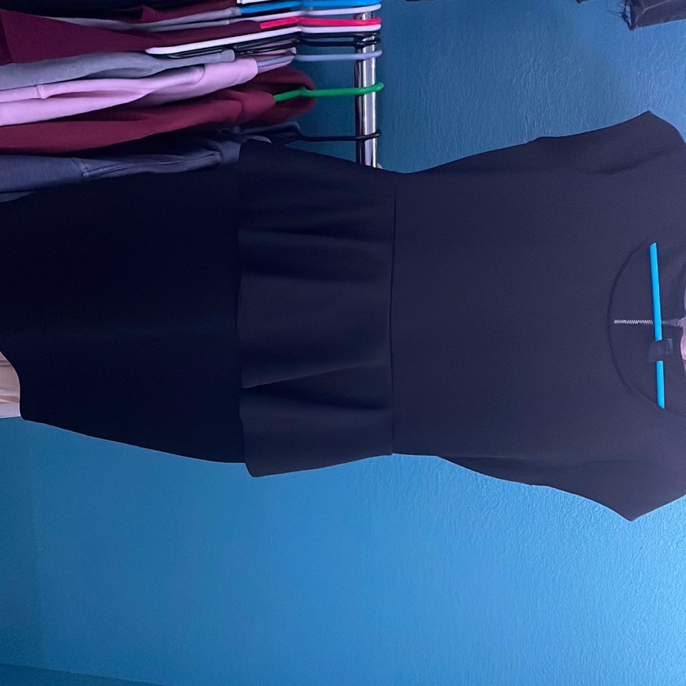 Black dress, lower thigh length, flowy piece at waist